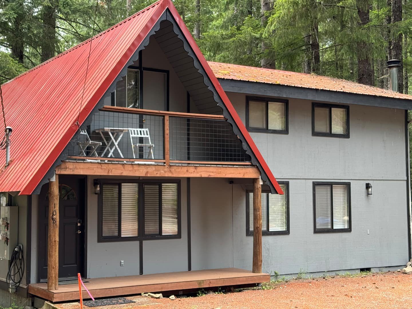 Tall Timber cabin with wraparound deck and red metal roof